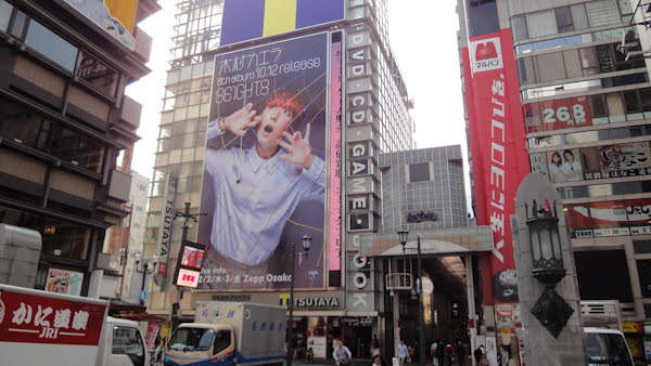 a giant poster of a young man dominates one of the area buidings